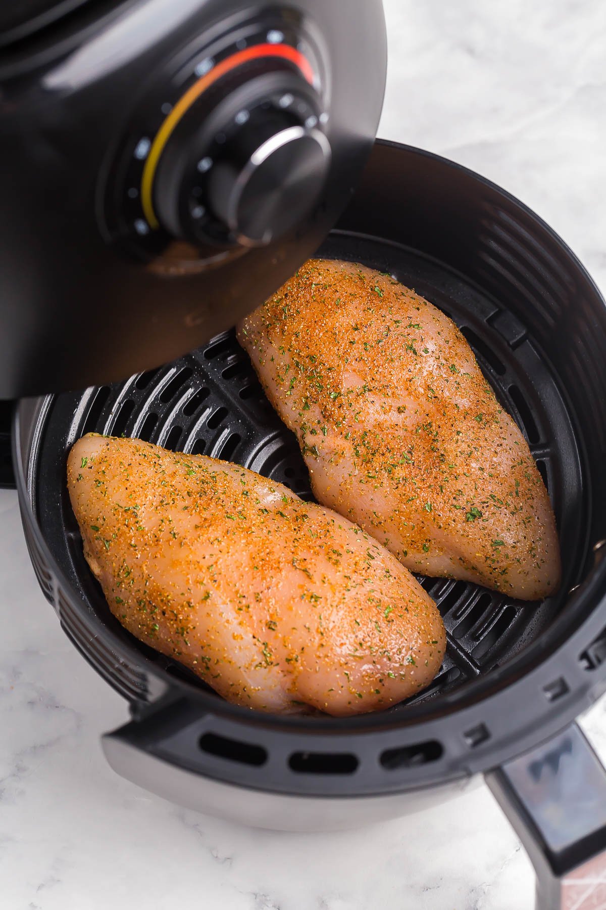 uncooked chicken breasts in air fryer.