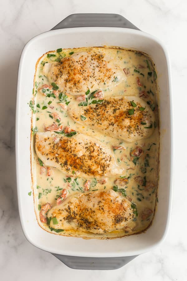 spinach added to baked chicken breasts with sauce