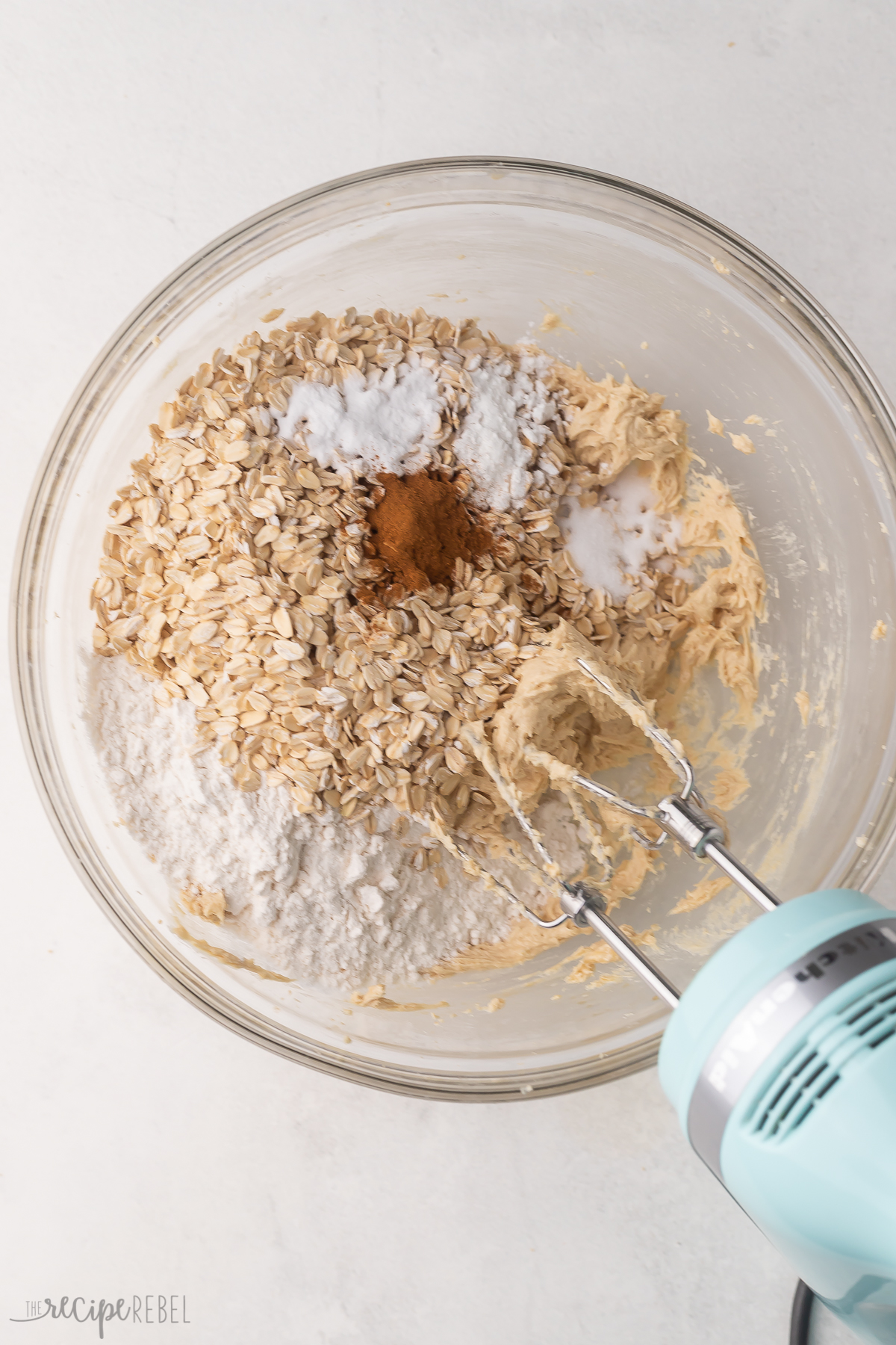Top view of a glass mixing bowl with dry ingredients being mixed into a creamed mixture