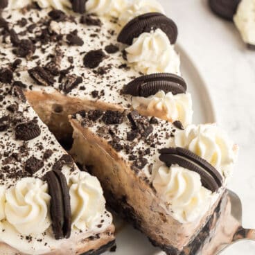 oreo ice cream cake whole with slice being pulled out on white plate